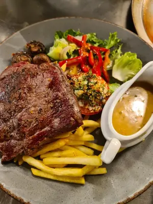 a plate of food with meat and fries and sauce at The Lamb and Flag Inn in Rhayader