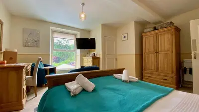 a bedroom with a blue bed with two pillows at Hafan Artro in Llanbedr