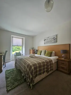 a bedroom with a large bed and a window at Hafan Artro in Llanbedr