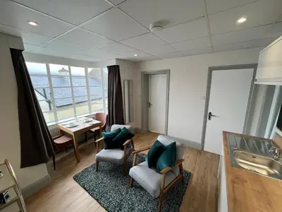 a living room with a large window and a sink at Sunray Suites in Barmouth