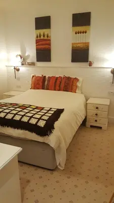 a bedroom with a large bed and some paintings on the wall at Tower Hotel in Talgarth