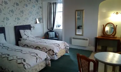 a hotel room with two beds and a table at Tower Hotel in Talgarth