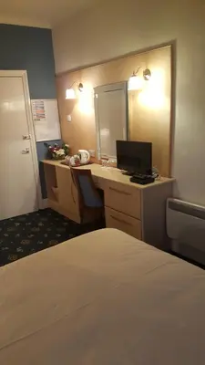 a hotel room with a bed and a desk with a computer at Tower Hotel in Talgarth