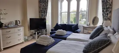 a hotel room with two beds and a television at Mellington Hall Country House Hotel in Church Stoke