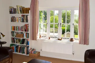 a window with a radiator in a room with books at The Oaks in Church Stretton