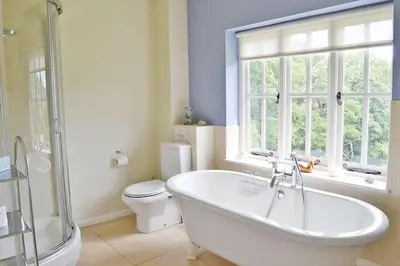 a bathroom with a tub and a toilet and a window at The Oaks in Church Stretton