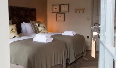 a bedroom with a bed with towels on it at George III Hotel in Penmaenpool