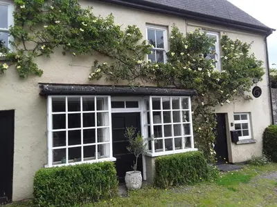 a white house with white windows and plants at 6 Bridge St. in Brecon