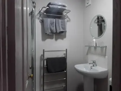 a white bathroom with a sink and a mirror at 6 Bridge St. in Brecon