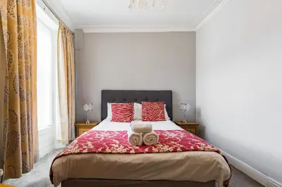 a bedroom with a bed with a teddy bear on it at Marine Studios in Aberystwyth