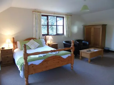 a bedroom with a large wooden bed and a couch at Pwllgwilym B & B in Builth Wells