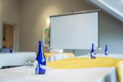 a blue bottle sitting on a table with a glass at Aberystwyth Park Lodge Hotel in Aberystwyth