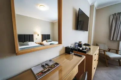 a hotel room with a bed and a mirror at Aberystwyth Park Lodge Hotel in Aberystwyth