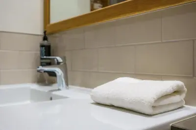 a stack of towels sitting on a bathroom sink at Aberystwyth Park Lodge Hotel in Aberystwyth