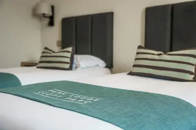 two beds with a green blanket on top of them at Aberystwyth Park Lodge Hotel in Aberystwyth