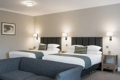 a hotel room with two beds and a couch at Aberystwyth Park Lodge Hotel in Aberystwyth