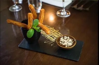 a table with a black plate with a plant and a bowl at The Lion in Leintwardine