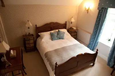 a bedroom with a large bed with blue pillows at The Lion in Leintwardine