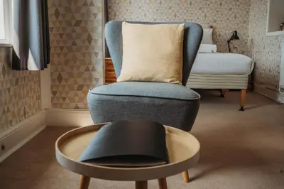 a chair and a table in a room with a bed at Three Wells B&B in Llandrindod Wells