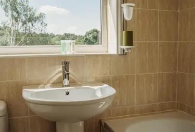 a bathroom with a sink and a window at Three Wells B&B in Llandrindod Wells
