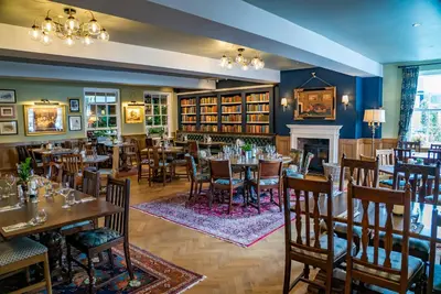 a restaurant with tables and chairs and a fireplace at Mytton and Mermaid - Brunning and Price in Shrewsbury