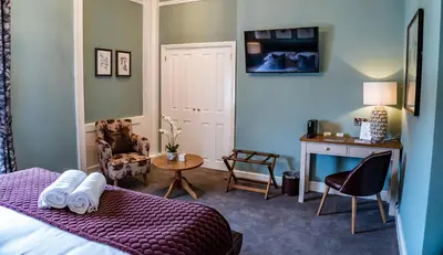 a bedroom with a bed and a desk and a table at Mytton and Mermaid - Brunning and Price in Shrewsbury