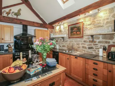 a kitchen with a bowl of fruit on a counter at Corn House in Plaish