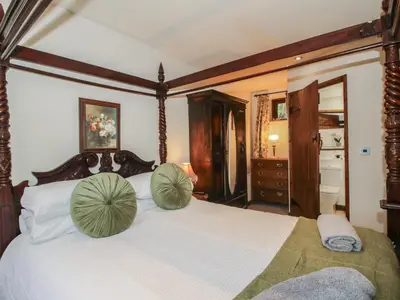 a bedroom with a bed with green pillows on it at Corn House in Plaish