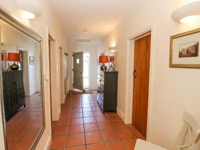 a hallway with a tile floor in a home at Virginia Cottage in Acton Burnell