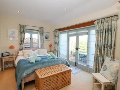 a bedroom with a bed and a large window at Virginia Cottage in Acton Burnell