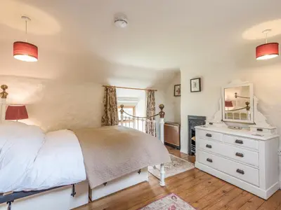 a bedroom with a bed and a dresser with a mirror at Hillgate House in Bromlow