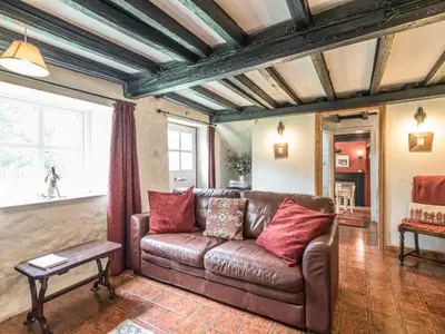 a living room with a brown leather couch at Hillgate House in Bromlow