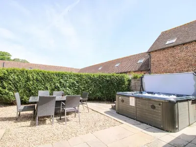 a backyard with a hot tub and a table and chairs at The Wain House in Acton Scott