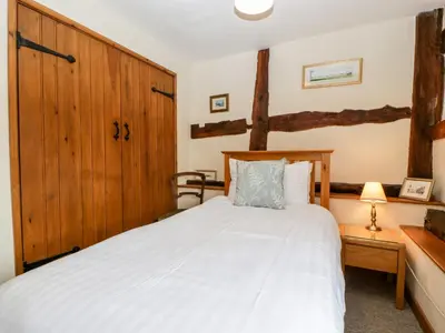 a bedroom with a bed and a wooden cabinet at Tippets View in Pembridge