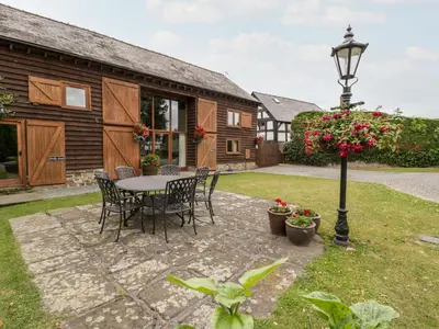 a patio with a table and chairs and a street light at Tippets View in Pembridge
