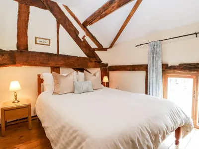 a bedroom with a large white bed and a window at Tippets View in Pembridge