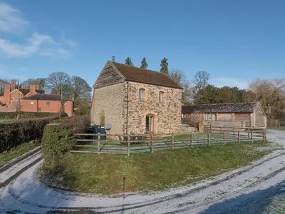 an old stone building on a dirt road at Glebe Barn in Caynham
