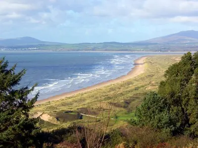 a view of a beach and the ocean from a hill at Trem y Mor in Harlech