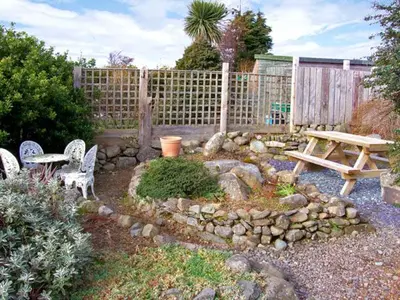 a garden with a picnic table and a bench at Trem y Mor in Harlech