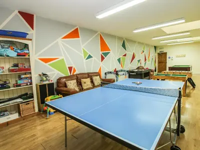 a ping pong table in the middle of a room at The Olde Cowshed in Acton Scott