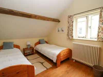 two twin beds in a room with a window at Old Coach House in Shrawardine