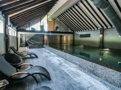 a swimming pool with chairs in a building at The Olde Cow House in Hughley