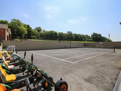 a tennis court with a tennis court at The Olde Cow House in Hughley