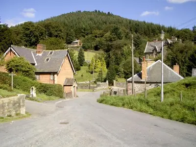 an empty road in a village with houses and trees at Happy Union Stables in Abbey-Cwmhir
