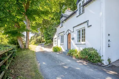 a white house with a road next to it at Braich-Y-Celyn Lodge in Aberdyfi