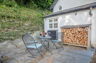 two chairs and a table in front of a building at Braich-Y-Celyn Lodge in Aberdyfi