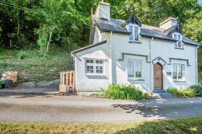 a small white house with a door on a street at Braich-Y-Celyn Lodge in Aberdyfi