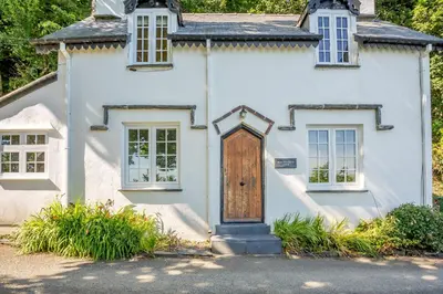 a white house with a wooden door at Braich-Y-Celyn Lodge in Aberdyfi