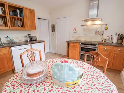 a kitchen with a table with a cake on it at Bryn Howell Stables in Trevor