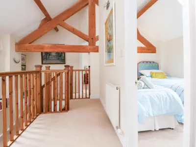 a bedroom with a bed and a staircase in a house at Bryn Howell Stables in Trevor